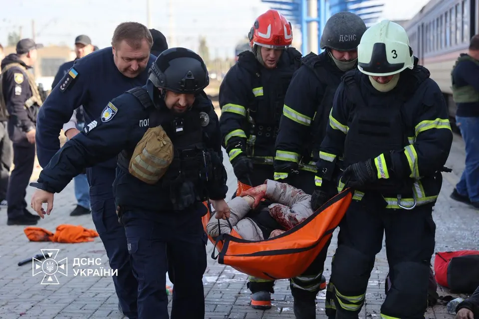 Rescue workers carry an injured passenger along the platform at Dnipro railway station