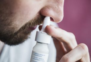 Close-up of man using nasal spray