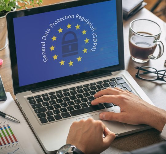 Man working with a computer, General Data Protection Regulation and European Union flag