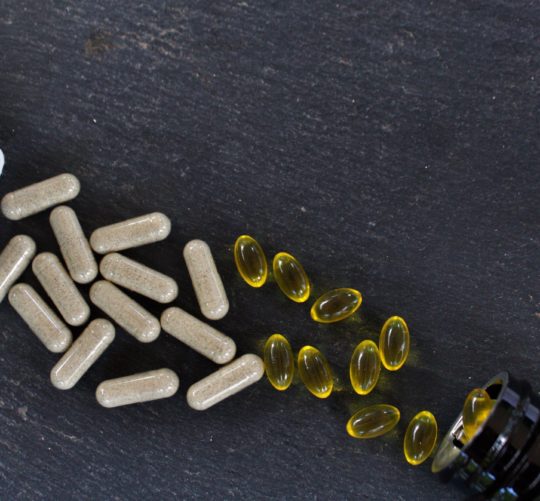 Top view of vitamin supplements on a black surface